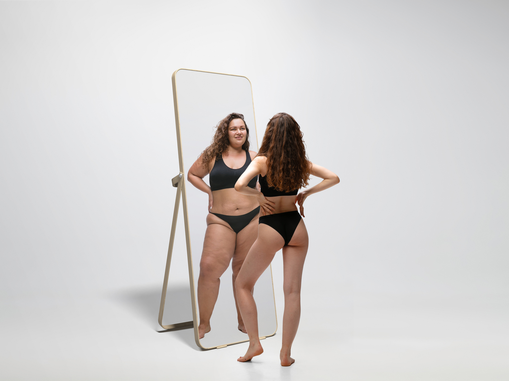 Fit Woman Looking at a Plus Size Reflection on Mirror